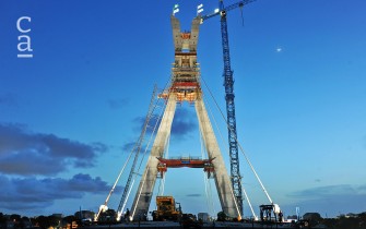Night-time view of pylon, cables & craneage during construction (julius-berger.com)