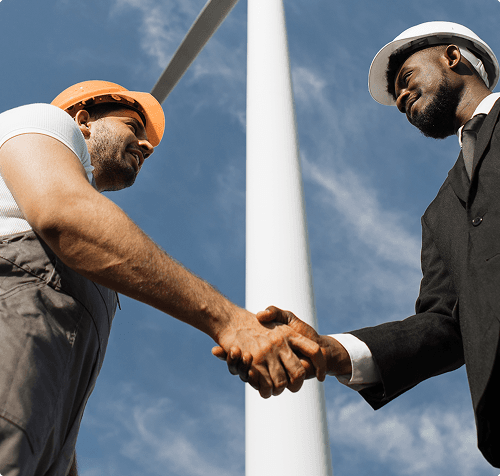 Two construction professionals shaking hands at an infrastructure site