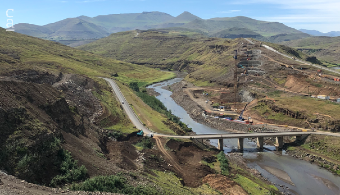 View of the construction site dwarfed by the majesty of the landscape. View of the construction site dwarfed by the majesty of the landscape.