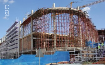 Ongoing construction with scaffolding in place, tall columns with connecting beams, and decorative facade panels being installed (moneyweb.co.za)